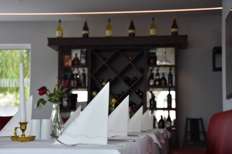 Weinregal mit Kerze und Rosen